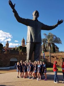 The Rishworth Hockey Team stand around the base of Nelson Mandela's Statue in 